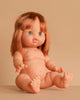 The Minikane Baby Doll (13") - Capucine, with light skin, blue eyes, and medium auburn hair, sits nude on a beige surface against a matching background. Clothing sold separately.