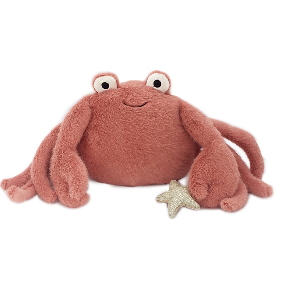 The Mon Ami - Caldwell Crab Plush Toy is a pink plush crab with a smiling face, round eyes, soft legs, and a small beige starfish. Ideal as a cute charm or collectible keychain to brighten any bag. Photographed on a white background.