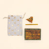 A Mouse Cake Topper—final sale—alongside a star-patterned drawstring pouch, a small ceramic pipe with keepsake charm, a yellow stick, and a wooden box labeled “camptellow” are arranged on a light background.