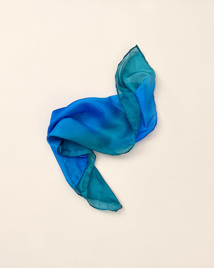A lightweight, Sarah's Silk Playsilk - Ocean casually laid out on a neutral background to highlight its smooth fabric and gentle folds.