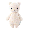 A Cuddle + Kind Baby Kitten with a smiling face, made of multicolored Peruvian cotton yarn, standing against a white background. The kitten has small ears and black stitched eyes.