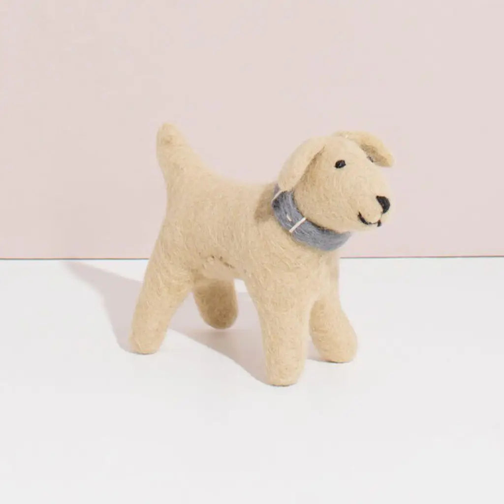A small, Hand Felted Wool Golden Retriever Dog with a blue collar standing against a soft pink background.