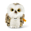 A Steiff, Wittie Owl plush toy with large yellow eyes, white and brown feathers, and a tag that reads "Steiff" on its left wing, prominently displaying a distinctive "Button in Ear," against a white background.