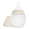 A Medical Grade Silicone Baby Bottle with a beige cap to the side, featuring a translucent nipple on top, isolated on a white background.