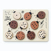Wooden Tray Puzzle - Count to 10 Ladybugs featuring round pieces with various dot patterns representing numbers, arranged on a board with decorative leaf and feather designs.