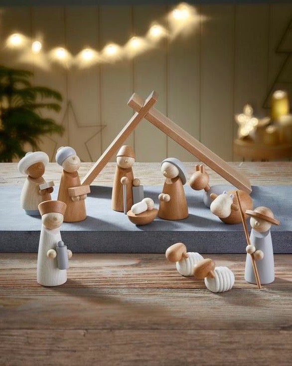A Wooden Nativity Scene with figurines including the holy family, shepherds, and animals under a star, set against a backdrop of soft lights and a translucent star.