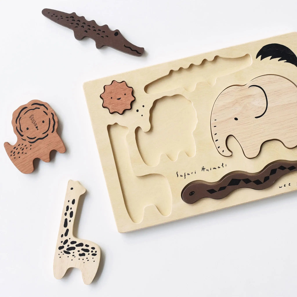 Wooden Tray Puzzle - Safari Animals with cut-outs and corresponding animal-shaped puzzle pieces including a giraffe, crocodile, tortoise, elephant, and snake on a white surface. This safari set is crafted from rubber.