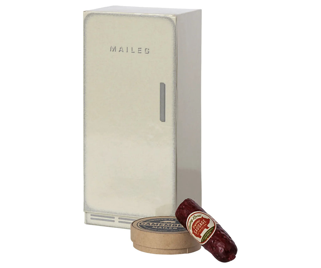 A Maileg Cooler-shaped box in an off-white color, accompanied by miniature toy food items including a can and a sausage with labels.