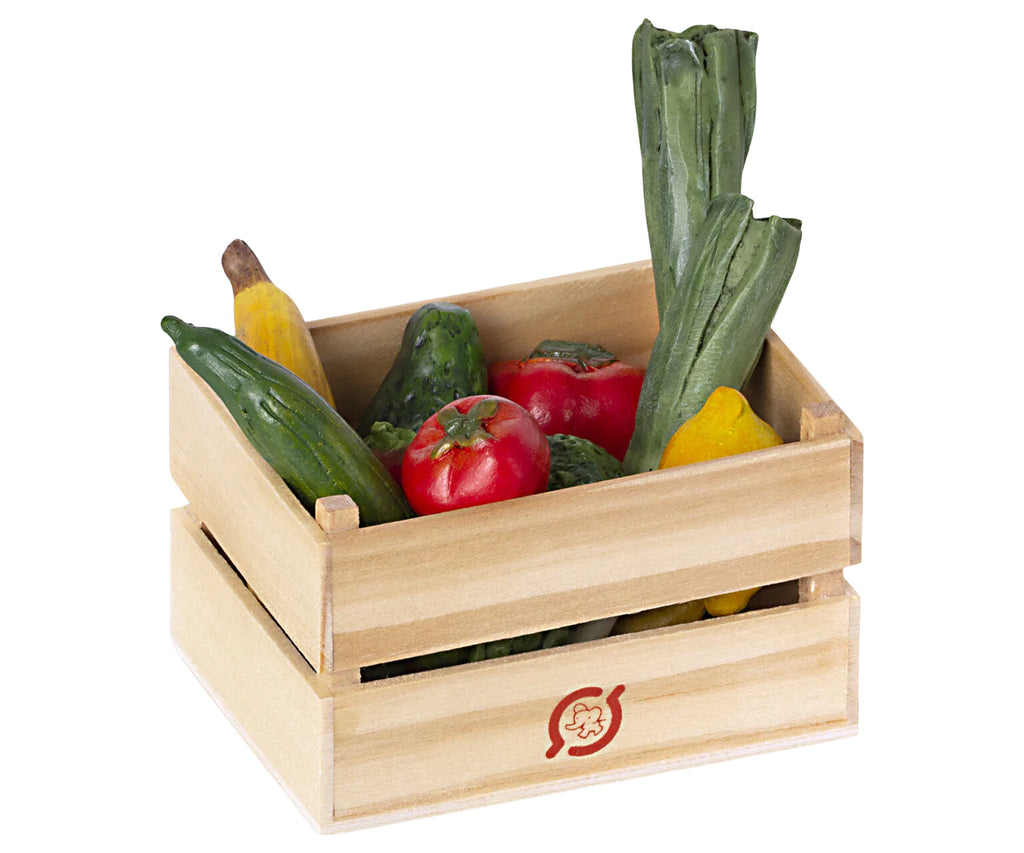 An Maileg Fruits & Veggies crate filled with various fresh vegetables including cucumbers, zucchinis, and bell peppers, isolated on a white background.