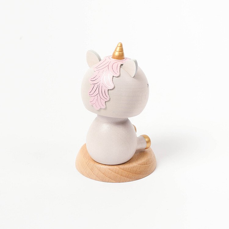 Sentence with Product Name: A Wooden Unicorn Bobblehead, viewed from the side, featuring a pink mane, a golden horn that allows its head to shake, and a tail, presented on a circular wooden base.