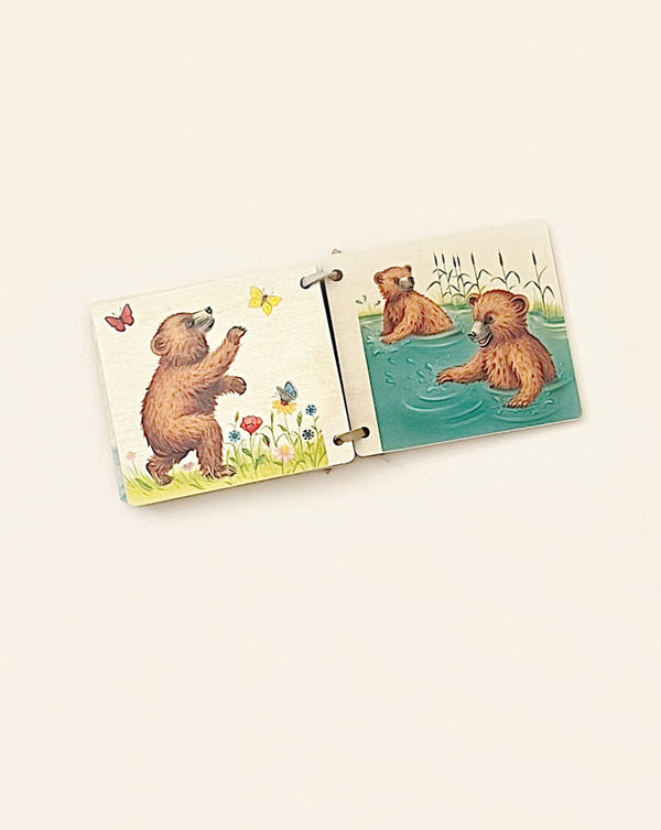 Two Wooden Picture Books - Bear made from sustainably harvested trees connected depicting a cheerful scene with illustrated bears, one standing on grass and the other in water, surrounded by butterflies and flowers.
