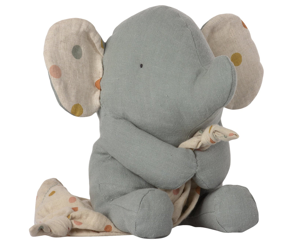 A Maileg Lullaby Friends - Elephant (Plays Music) in a sitting position, hugging a small blanket with pastel polka dots, ideal for baby gifts, isolated on a white background.