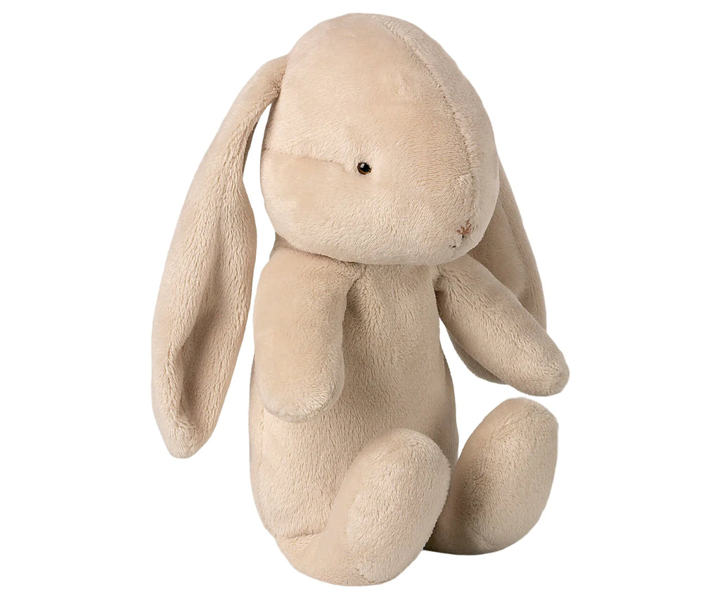 A Maileg Bunny Holly with long floppy ears, sitting upright. Its fur is a soft beige color, and it has black eyes and a tiny stitched nose. The bunny appears soft and cuddly.