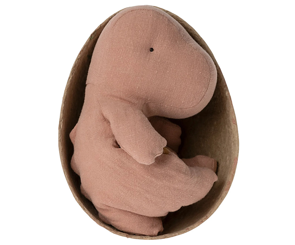 A Small Gantosaurus from Maileg, made with a light brown fabric texture, is nestled inside a half-open egg-shaped container crafted from brown paper-like material. This huggable Rose Gantosaurus toy is in a sitting position with its head slightly tilted forward, making it perfect for fans of cuddly toys.