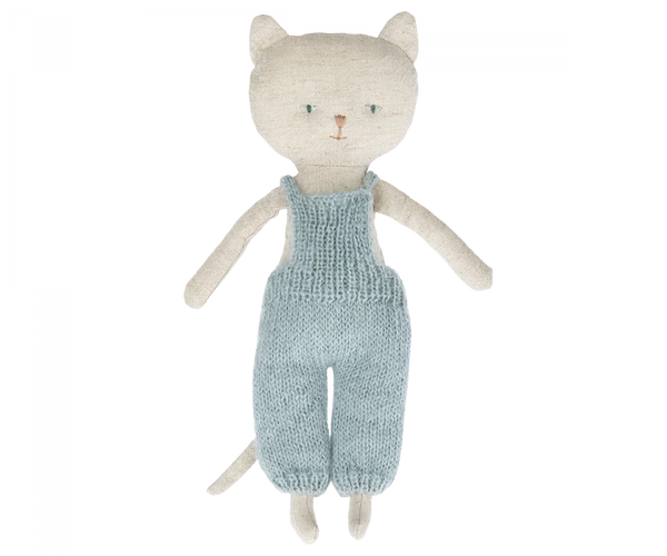 A handmade Maileg Cat Stuffed Animal standing upright, wearing a teal knitted overall, featuring large eyes and whiskers, crafted from textured light gray fabric on a black background.