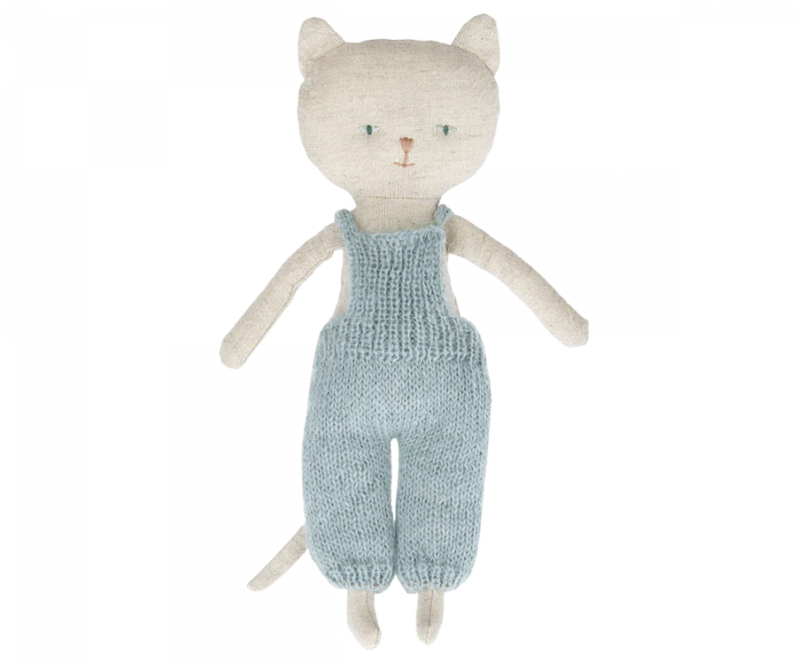 A handmade Maileg Cat Stuffed Animal standing upright, wearing a teal knitted overall, featuring large eyes and whiskers, crafted from textured light gray fabric on a black background.