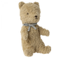 A small, beige Maileg My First Teddy, Sand with a fuzzy texture sits upright. It has round, dark eyes, a small dark nose, and a neutral expression. The teddy is wearing a light blue ribbon tied in a bow around its neck—a perfect classic baby keepsake for any new born baby gift.