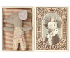 a small mouse doll inside a match box, sleeping with a blanket.