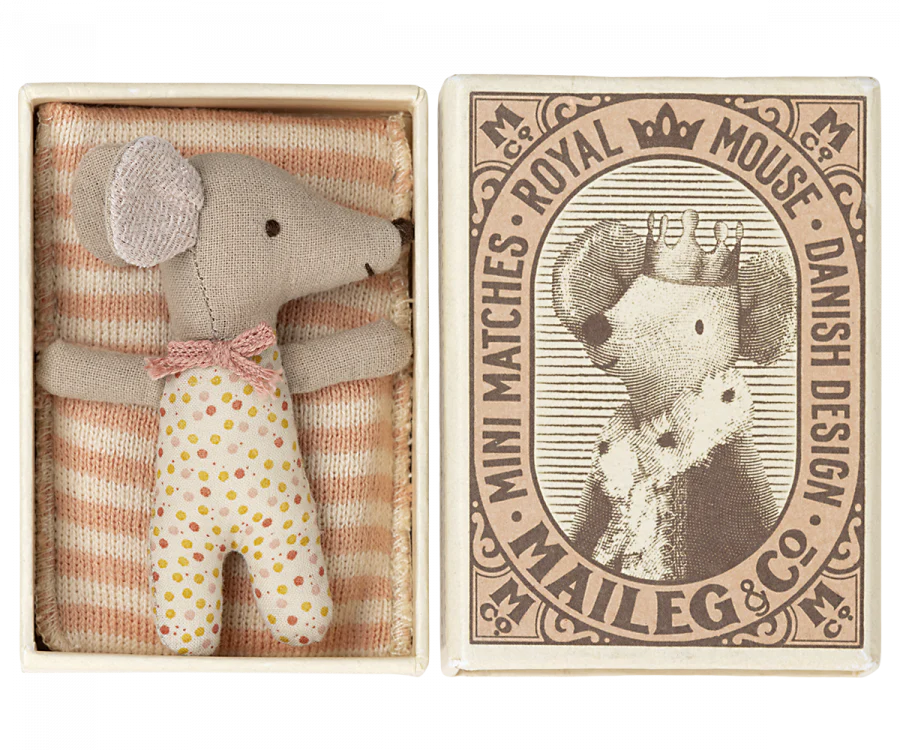 a small mouse doll inside a match box, with a blanket.