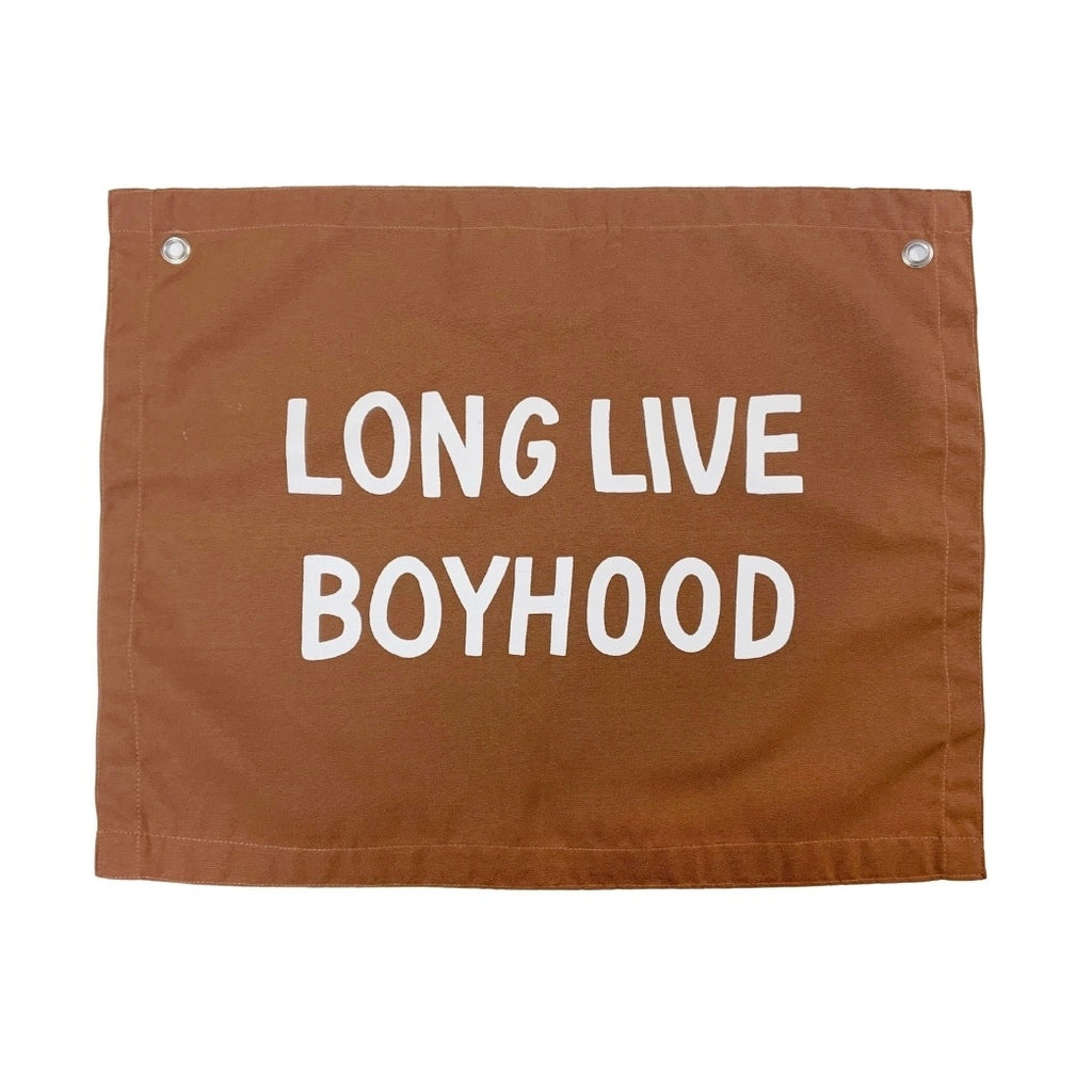 Long live boyhood in rust color photographed against white wall. 