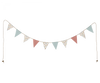 A string of decorative Maileg Miniature Garland bunting with triangular flags in various patterns and colors such as polka dots and stripes, dangling against a black background.