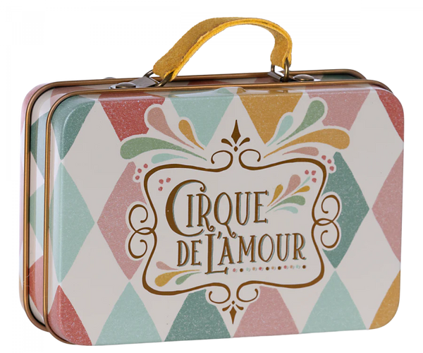 The Maileg Suitcase, Small—a metal suitcase with a yellow handle, decorated in a pastel harlequin pattern and adorned with the phrase “Cirque de l’Amour” on the front—offers a charming storage solution for small items or an enchanting way to present small gifts.
