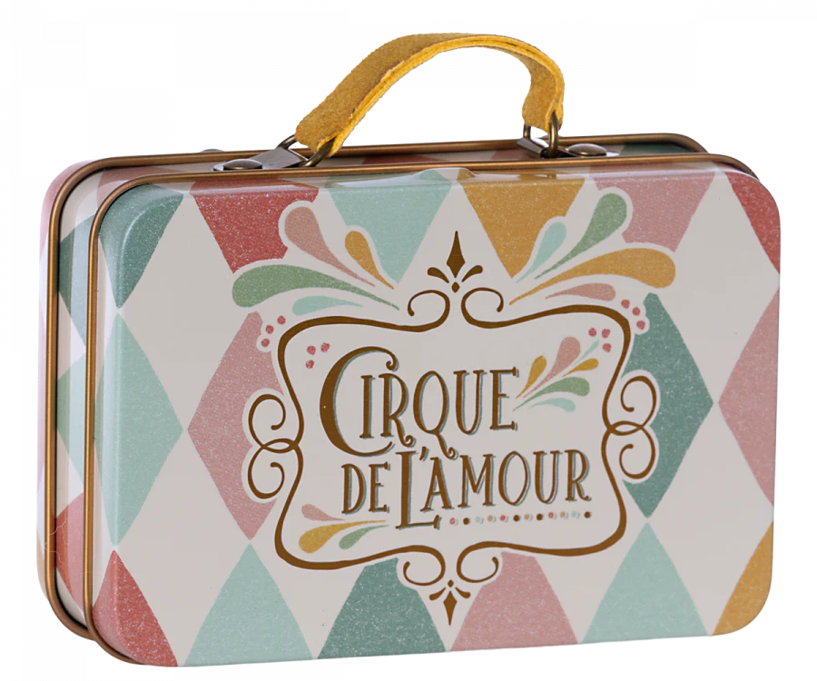 The Maileg Suitcase, Small—a metal suitcase with a yellow handle, decorated in a pastel harlequin pattern and adorned with the phrase “Cirque de l’Amour” on the front—offers a charming storage solution for small items or an enchanting way to present small gifts.