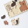 A sustainably sourced Wooden Tray Puzzle - Woodland Animals featuring animal shapes including a bear, rabbit, hedgehog, squirrel, and bird, with some pieces removed and placed beside the board.
