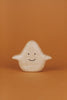 A small, cute Wooden Ghost Emotions figure with a simple, smiling face and outstretched arms is set against a solid orange background. The light-colored figure, treated with natural linseed oil, showcases a smooth texture that evokes basic emotions of joy and warmth.