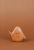 A small, smooth Wooden Ghost Emotions with an angry expression, finished with natural linseed oil. The ghost has two black dots for eyes and a frowning mouth, embodying basic emotions. The background is a solid, warm brown color.