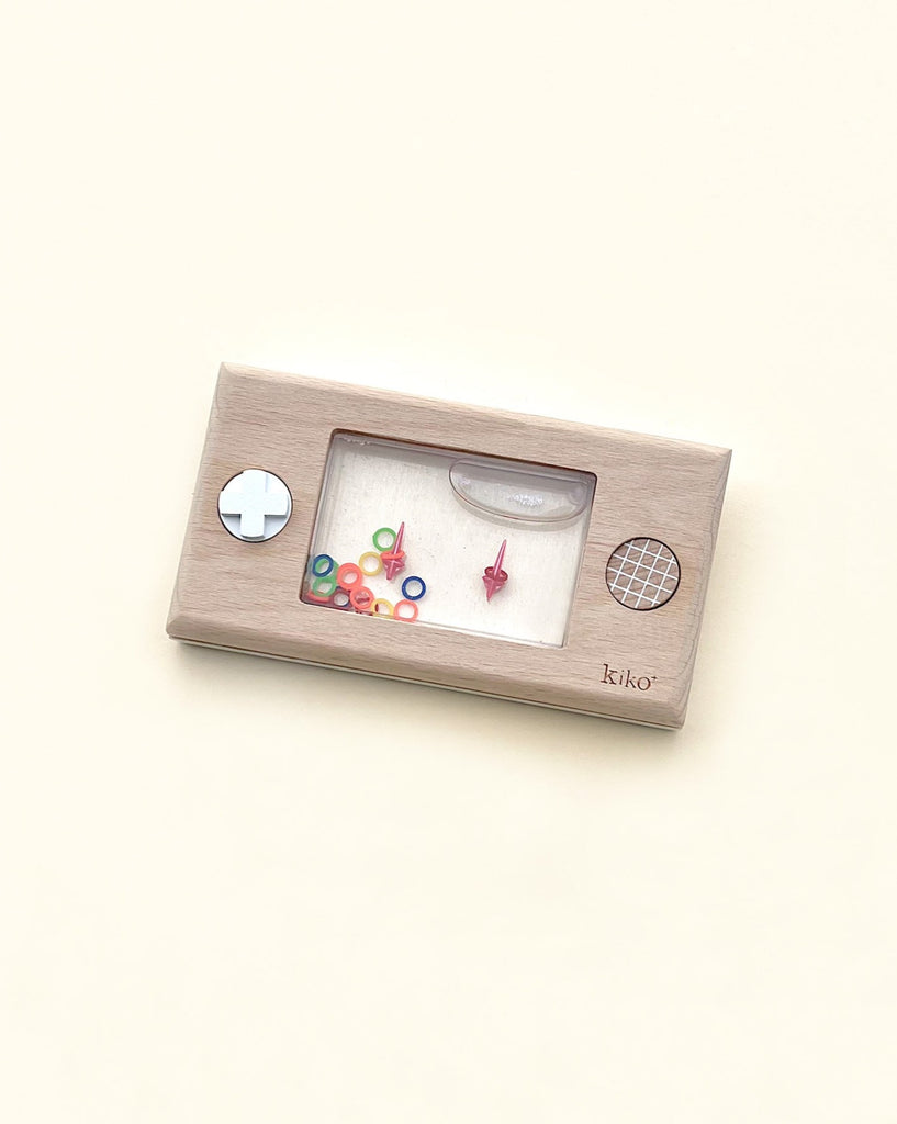 A Retro Wooden Water Game featuring colorful knobs and a screen displaying colorful beads and shapes, against a pale yellow background.