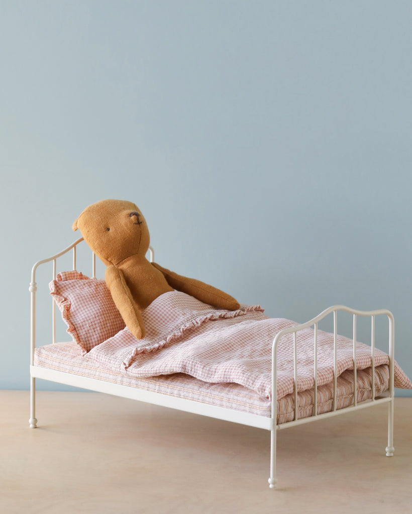 Toy doll bed with teddy bear sleeping in it