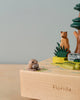 A Florida Wooden Music Box featuring a small, carved manatee in the foreground and a bear by a tree in the background, set against a neutral background.