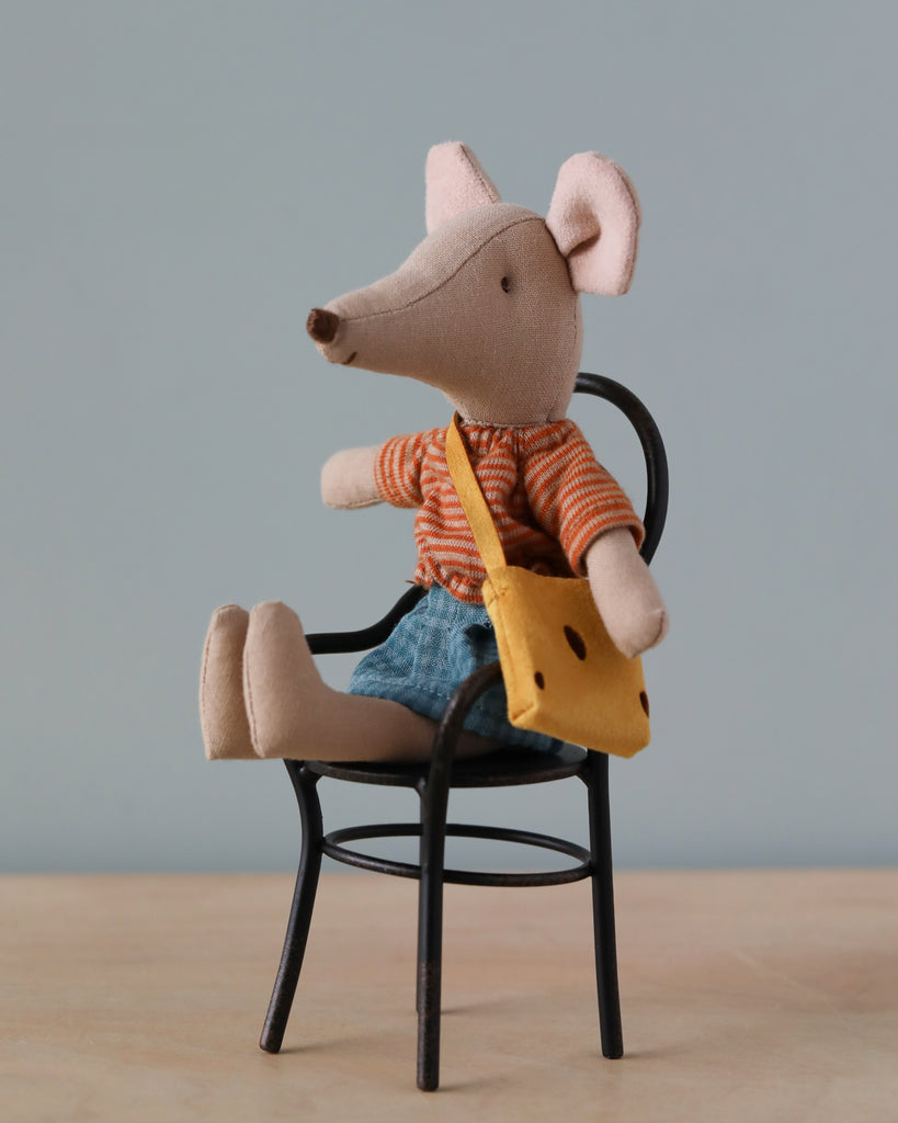 A handmade Maileg Mum Mouse doll with a pointy nose and large ears, dressed in mum mouse clothes featuring an orange striped shirt, denim shorts, and carrying a yellow sling bag, seated on a