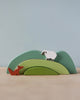 A Green Hill Stacker comprising three nested solid wood hills, forming a hill, with a toy sheep on the top arch and a toy fox on the bottom arch against a pale blue background.