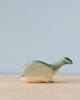 Handmade Holzwald Whale toy on a neutral background, featuring simplistic design and smooth finish with a blend of natural wood tones and green paint. This sustainable toy exemplifies high-quality craftsmanship that appeals to both aesthetic and