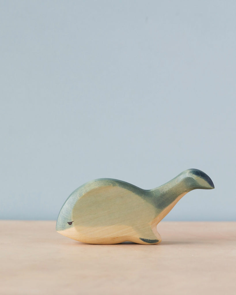 Handmade Holzwald Whale toy on a neutral background, featuring simplistic design and smooth finish with a blend of natural wood tones and green paint. This sustainable toy exemplifies high-quality craftsmanship that appeals to both aesthetic and
