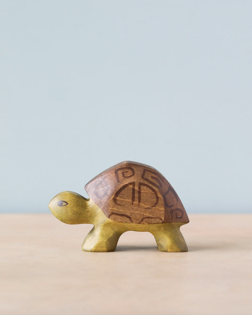 A high-quality Handmade Holzwald Turtle figurine with a distinct pattern on its shell, standing against a plain light blue background.