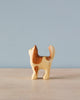 A Handmade Holzwald Cat figurine, crafted from high-quality wood, with a light tan body and brown patches, standing upright against a plain blue background.