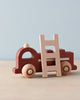 A Mini Wooden Fire Truck with a removable ladder on top, painted in red and natural wood colors, set against a neutral blue backdrop.