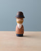 A Handmade Peg Doll - Dad of a man with a mustache, wearing a brown bowler hat, a brown coat over a white shirt and navy trousers, against a plain blue background.