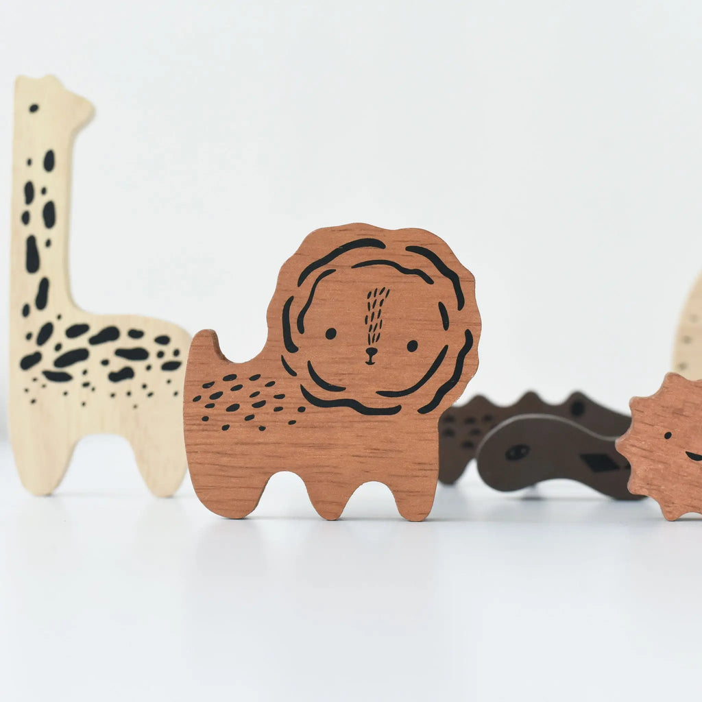 Wooden Tray Puzzle - Safari Animals, including a lion, giraffe, and crocodile, lined up on a light background, showcasing distinct, carved details and patterns.