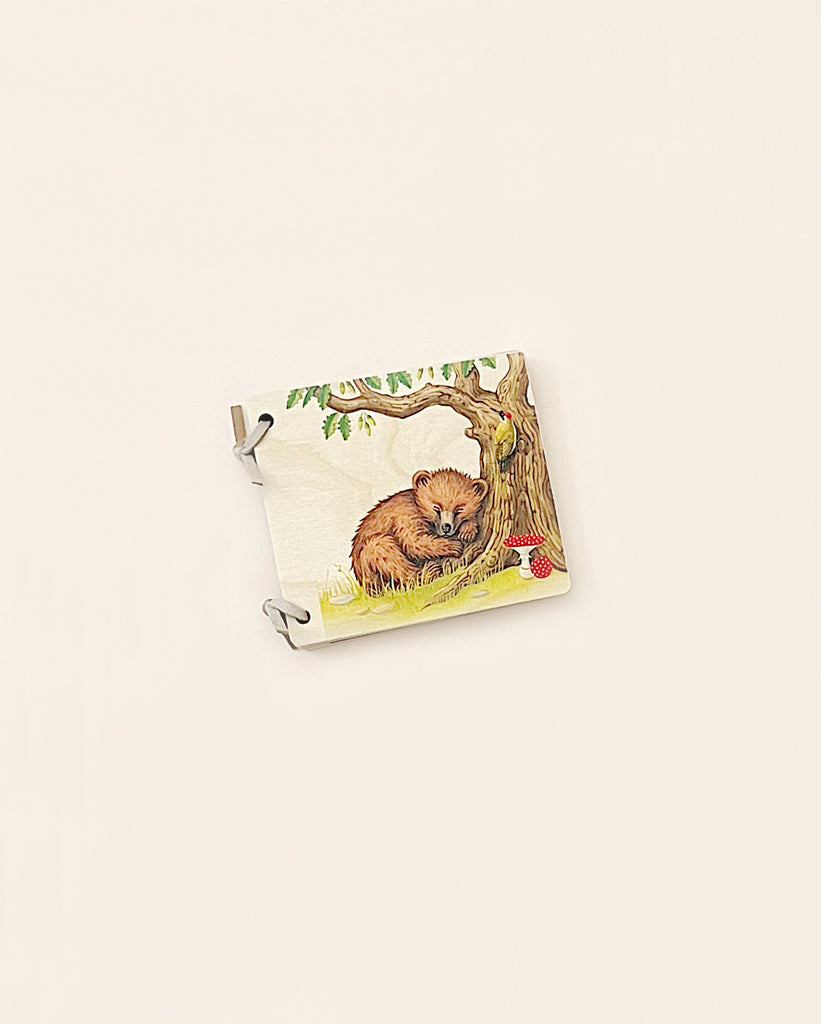 An illustrated puzzle piece featuring a bear cub resting by a tree and some red berries, set against a plain, light background, made from sustainably harvested trees.
Product Name: Wooden Puzzle Piece - Bear