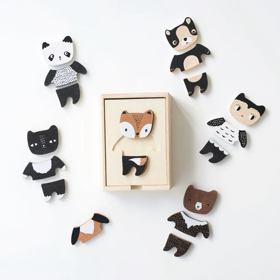A collection of Mix & Match Animal Tiles, including pandas and foxes, artistically arranged around a box on a light gray background. Each tile has a unique black and white pattern, ideal for creative play.