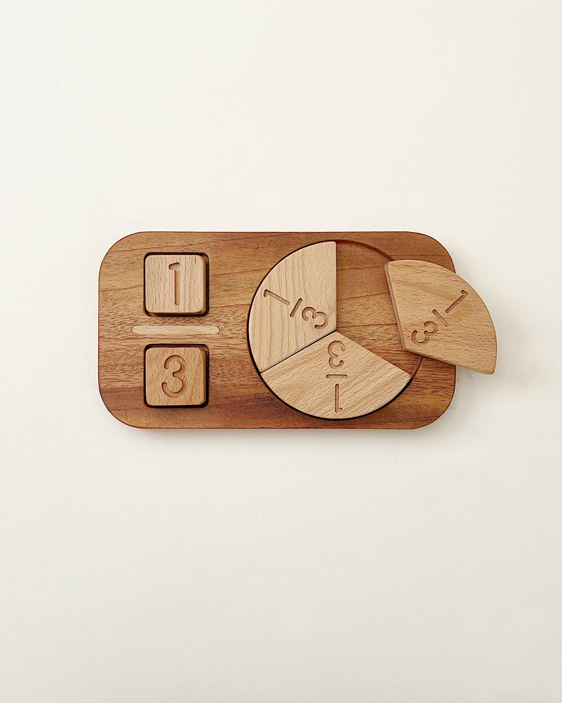 Wooden Fraction Puzzle - Made in USA on a white background, shaped like a circle divided into five parts with numbers and mathematical symbols, placed on a rectangular tray.