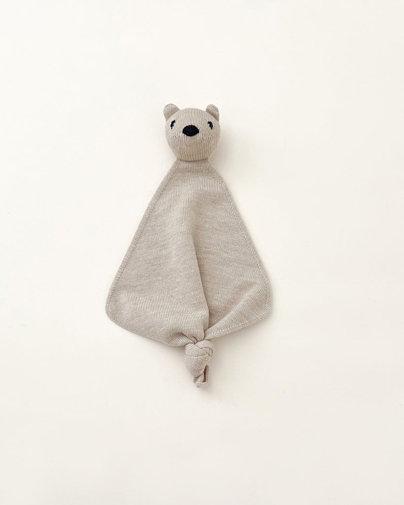 A beige colored small merino wool lovey with a head of a teddy bear at top.