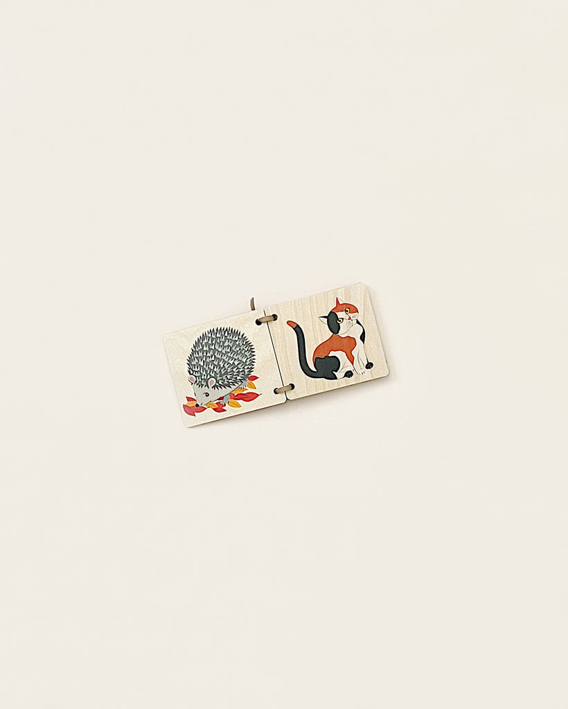 A Wooden Picture Book - Animals puzzle piece made from sustainably harvested trees, featuring illustrations of a hedgehog and a cat, placed on a plain white background.