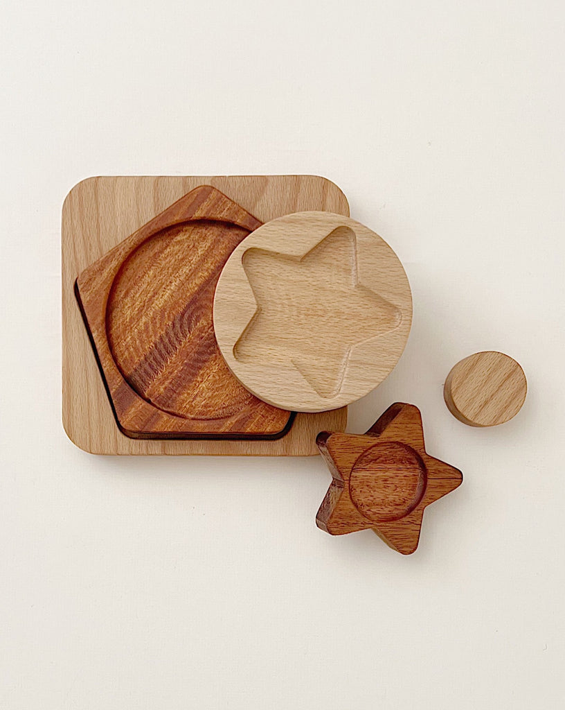 Various wooden plates and coasters made from beech and sapele wood, including a star-shaped and circular design, arranged on a light background.