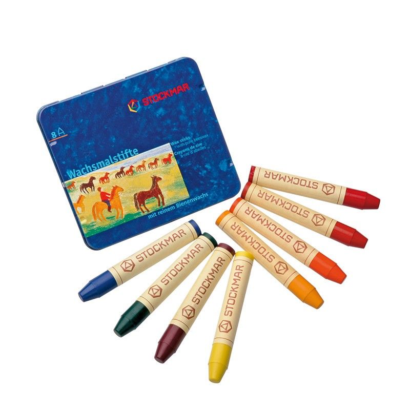 An open tin of non-toxic Stockmar Wax Stick Crayons Waldorf Tin Case with eight assorted vibrant crayons (red, blue, green, yellow, orange, brown) arranged beside it, on a plain white background.