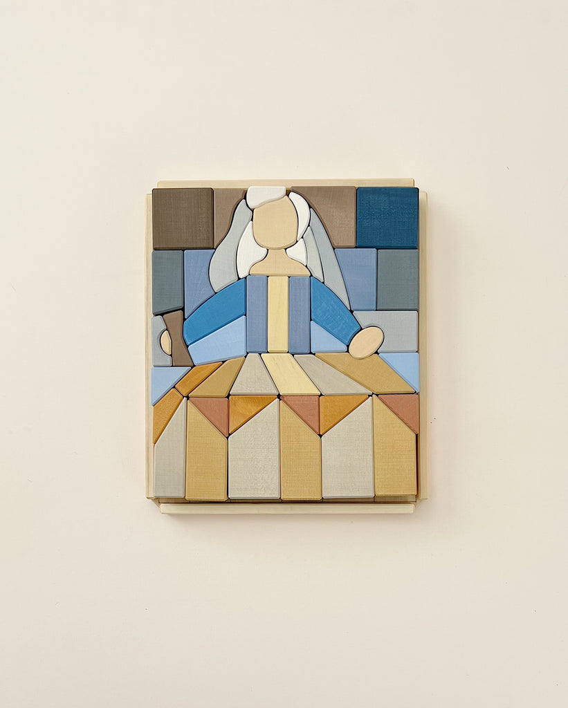 A Raduga Grez Infante Blocks puzzle art piece depicting a woman seated in meditation, formed with variously shaped and colored building blocks creating an abstract, geometric design.